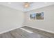 Minimalist bedroom with wood-look flooring, neutral walls, and a backyard-facing window at 8418 Flagstone Dr, Tampa, FL 33615