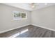 Empty bedroom with gray luxury vinyl flooring, neutral paint, white trim and a window at 8418 Flagstone Dr, Tampa, FL 33615