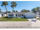 Charming single Gathering home featuring a lush front lawn, a beautiful garden, palm trees and two-car garage at 8418 Flagstone Dr, Tampa, FL 33615