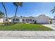 Charming single Gathering home featuring a lush front lawn, a beautiful garden, palm trees and two-car garage at 8418 Flagstone Dr, Tampa, FL 33615