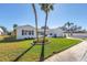 Charming single-story home with a manicured lawn, palm trees, tasteful landscaping and a two car garage at 8418 Flagstone Dr, Tampa, FL 33615