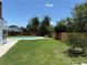 Backyard features a sparkling pool surrounded by lush greenery and wood fence at 8418 Flagstone Dr, Tampa, FL 33615