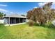 Lush backyard with a screened lanai, a mature tree, and a well-manicured lawn at 10322 Goldenbrook Way, Tampa, FL 33647