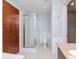 Modern bathroom with a glass shower, white tiled walls, and a wood door at 111 N 12Th St # 1619, Tampa, FL 33602