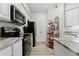 Efficient kitchen with stainless steel appliances, modern cabinets, and laminate flooring at 1203 Bay Club Cir # 1203, Tampa, FL 33607