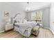 Airy main bedroom featuring light hardwood floors, large window, and stylish white furniture at 1203 Bay Club Cir # 1203, Tampa, FL 33607