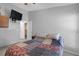 Cozy bedroom with a TV, closet, and a colorful quilt on the bed, bathed in natural light at 16211 Rambling Vine W Dr, Tampa, FL 33624