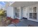 Close-up of a light blue home with a white front door, shutters, and landscaped front at 16211 Rambling Vine W Dr, Tampa, FL 33624