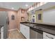 Well-maintained kitchen with black granite countertops, stainless steel dishwasher and view of the dining area at 16211 Rambling Vine W Dr, Tampa, FL 33624