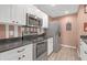 Well-lit kitchen with stainless steel appliances, white cabinets, and dark countertops for a modern cooking space at 16211 Rambling Vine W Dr, Tampa, FL 33624
