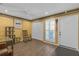 Bright living room featuring wood floors, closet, unique yellow accent wall, and natural light at 16211 Rambling Vine W Dr, Tampa, FL 33624
