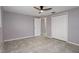Neutral bedroom featuring tile flooring, ceiling fan, and closet for ample storage at 4925 Beacon Hill Dr, New Port Richey, FL 34652