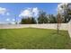 Large, level backyard enclosed by a white fence and mature trees at 6684 Devlin Ln, Wesley Chapel, FL 33545
