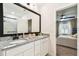 Bright bathroom featuring double granite vanity, large mirror and view to bedroom at 6684 Devlin Ln, Wesley Chapel, FL 33545