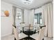 Corner dining area featuring a modern glass table and chairs near a window and sliding glass doors at 6684 Devlin Ln, Wesley Chapel, FL 33545