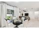 Bright dining area with a glass table and seating adjacent to the living area and sliding doors to the outdoor patio at 6684 Devlin Ln, Wesley Chapel, FL 33545