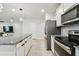 Open kitchen with granite island, stainless steel appliances, and sleek white cabinetry at 6684 Devlin Ln, Wesley Chapel, FL 33545