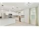 Bright kitchen featuring stainless steel appliances, granite countertops, white cabinets, and a window with curtains at 6684 Devlin Ln, Wesley Chapel, FL 33545