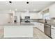 Modern kitchen equipped with stainless appliances, white cabinets, granite countertops, and modern lighting fixtures at 6684 Devlin Ln, Wesley Chapel, FL 33545