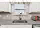 Close-up of kitchen sink area with granite countertops and stainless steel fixtures at 6684 Devlin Ln, Wesley Chapel, FL 33545