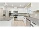 Well-lit kitchen equipped with stainless appliances, granite countertops, white cabinets, and a sink with a black faucet at 6684 Devlin Ln, Wesley Chapel, FL 33545