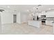 Open-concept kitchen with stainless steel appliances, granite countertops, and white cabinetry adjoining the living area at 6684 Devlin Ln, Wesley Chapel, FL 33545