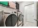 Bright laundry room featuring modern washer and dryer and shelving for storage at 6684 Devlin Ln, Wesley Chapel, FL 33545