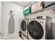 Functional laundry room features modern washer and dryer and shelving for supplies at 6684 Devlin Ln, Wesley Chapel, FL 33545