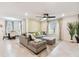 Open-concept living room showcasing a large sectional sofa, ceiling fan, and natural light at 6684 Devlin Ln, Wesley Chapel, FL 33545