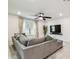 Inviting living room with a sectional sofa, ceiling fan, and mounted television, perfect for relaxation and entertainment at 6684 Devlin Ln, Wesley Chapel, FL 33545