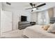 Bright bedroom featuring a ceiling fan, TV, large window, and neutral walls at 6684 Devlin Ln, Wesley Chapel, FL 33545