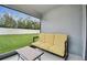 Cozy screened patio furnished with a comfortable sofa and a view of the green, fenced backyard at 6684 Devlin Ln, Wesley Chapel, FL 33545
