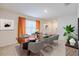 Modern dining area with a glass table, six chairs, and neutral tones with orange accents at 682 Olive Conch St, Ruskin, FL 33570