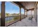A covered balcony with brown pillars overlooking a canal and featuring wrought iron chairs and tile flooring at 801 Brightwaters Ne Blvd, St Petersburg, FL 33704