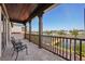 A covered balcony with brown pillars overlooking a canal and featuring wrought iron chairs and tile flooring at 801 Brightwaters Ne Blvd, St Petersburg, FL 33704