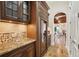 Elegant bar area with custom cabinetry, granite countertops, wine cooler, and glass display cabinets at 801 Brightwaters Ne Blvd, St Petersburg, FL 33704