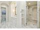The bright bathroom hallway has a commode and sink, marble floors, and a glass walk-in shower at 801 Brightwaters Ne Blvd, St Petersburg, FL 33704