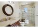 Bathroom featuring walk-in shower with glass door, modern vanity with sink, and decorative round mirror at 801 Brightwaters Ne Blvd, St Petersburg, FL 33704
