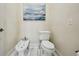A half-bath with light cream paint and a commode, bidet, and white marble flooring at 801 Brightwaters Ne Blvd, St Petersburg, FL 33704