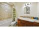 Bathroom showcasing a tub-shower combo, toilet, and single sink vanity with decorative mirror at 801 Brightwaters Ne Blvd, St Petersburg, FL 33704