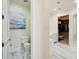 A hallway between the water closet and a walk-in closet featuring white marble floors and light cream paint at 801 Brightwaters Ne Blvd, St Petersburg, FL 33704