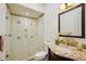 Bathroom features a glass-enclosed shower, toilet, and granite countertop vanity with decorative mirror at 801 Brightwaters Ne Blvd, St Petersburg, FL 33704