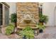 Courtyard fountain with potted plants and brick pavers providing a tranquil and elegant setting at 801 Brightwaters Ne Blvd, St Petersburg, FL 33704