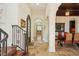 Hallway with tile floors, arched doorways, and decorative iron stair railing at 801 Brightwaters Ne Blvd, St Petersburg, FL 33704