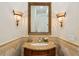 Charming powder room featuring an ornate mirror, designer sconces, and a custom vanity at 801 Brightwaters Ne Blvd, St Petersburg, FL 33704
