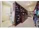 A large walk-in closet with dark wood built-in shelving and an adjacent laundry room and built-in ironing board at 801 Brightwaters Ne Blvd, St Petersburg, FL 33704