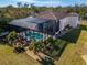 Aerial view of the house with large, screened-in pool, surrounded by mature trees and landscaping at 9401 93Rd St, Seminole, FL 33777