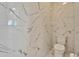 Bright modern bathroom featuring marble tiled walls, tile floors, and a modern toilet at 9401 93Rd St, Seminole, FL 33777