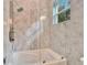 Modern bathroom featuring a glass-enclosed shower and tub combo with premium fixtures at 9401 93Rd St, Seminole, FL 33777