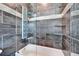 Luxurious shower and tub area with stylish gray tile, rainfall shower head, glass doors and glass shelves at 9401 93Rd St, Seminole, FL 33777